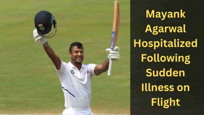 Mayank Agarwal raising his bat in celebration of a century on the cricket field, with text overlay on the right stating "Mayank Agarwal Hospitalized Following Sudden Illness on Flight.